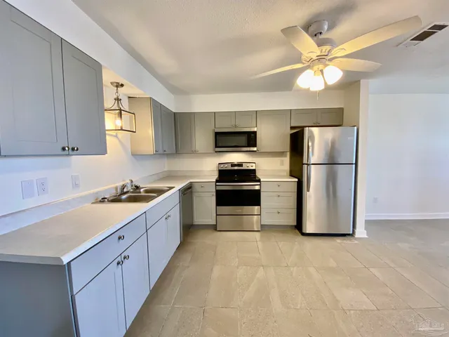 a large kitchen with a refrigerator a sink a stove a microwave and island