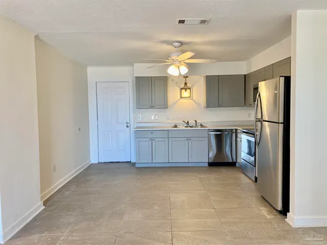 a kitchen with stainless steel appliances a sink and a refrigerator