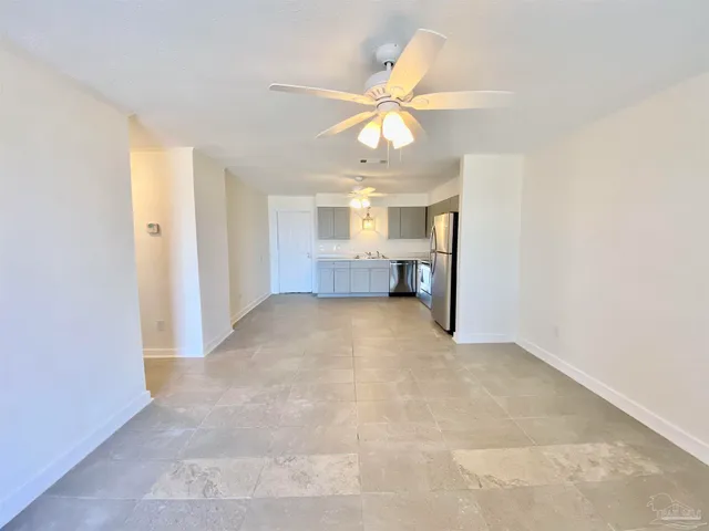 an empty room with a ceiling fan and a window