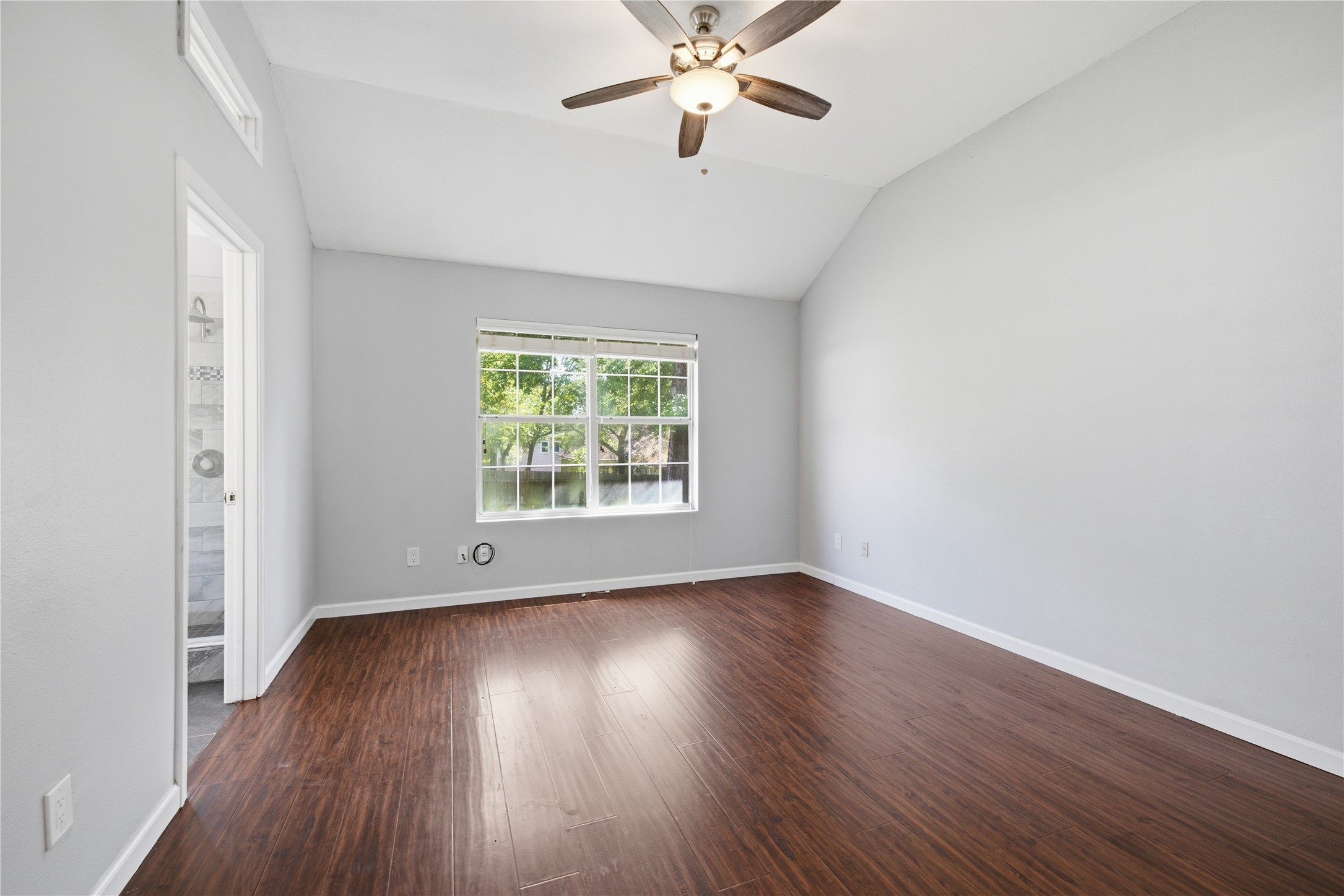 2922 Wickersham Lane Austin, TX 78741 - Photo 6 of 26 an empty room with wooden floor chandelier fan and windows