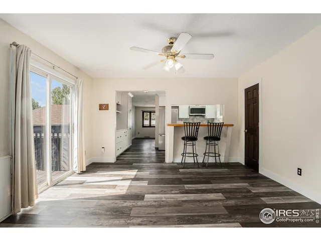 a view of a livingroom with furniture wooden floor ceiling fan and window
