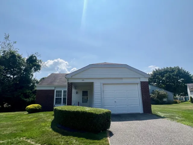 a front view of a house with a garden and yard
