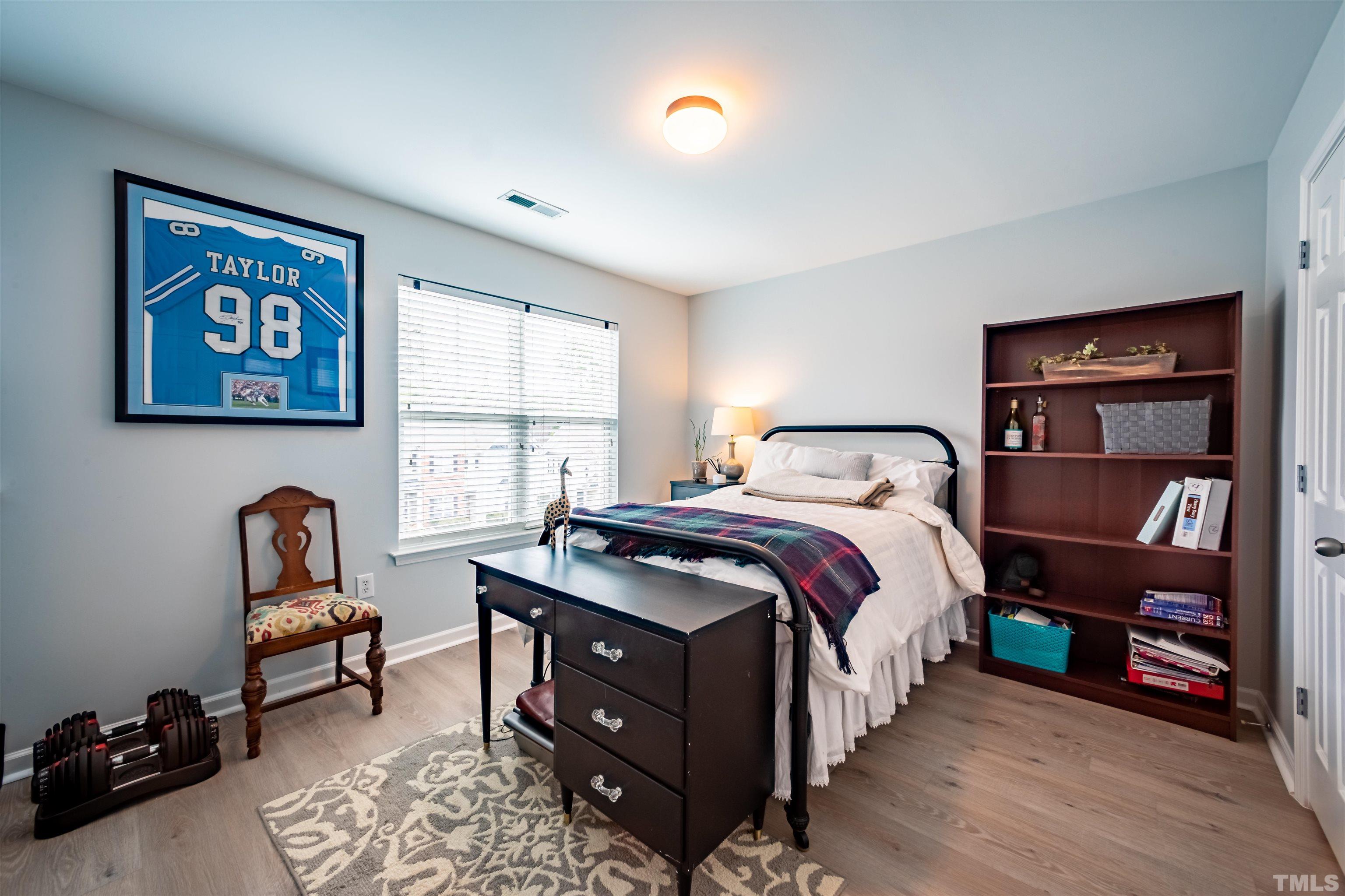 8447 Central Drive Raleigh, NC 27613 - Photo 14 of 19 a bedroom with a bed and a chair in it
