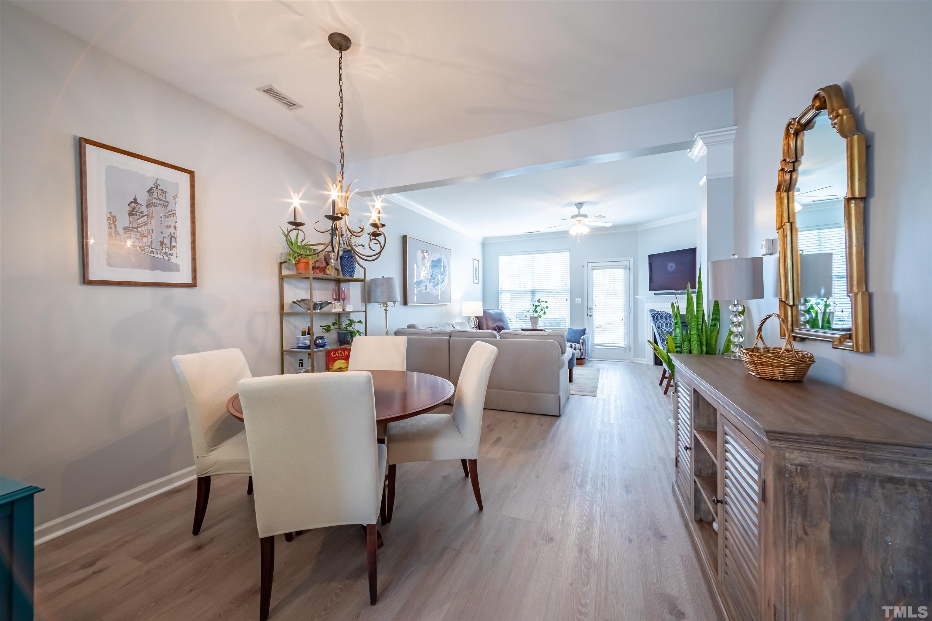 8447 Central Drive Raleigh, NC 27613 - Photo 2 of 19 a view of a dining room and livingroom with furniture wooden floor a chandelier