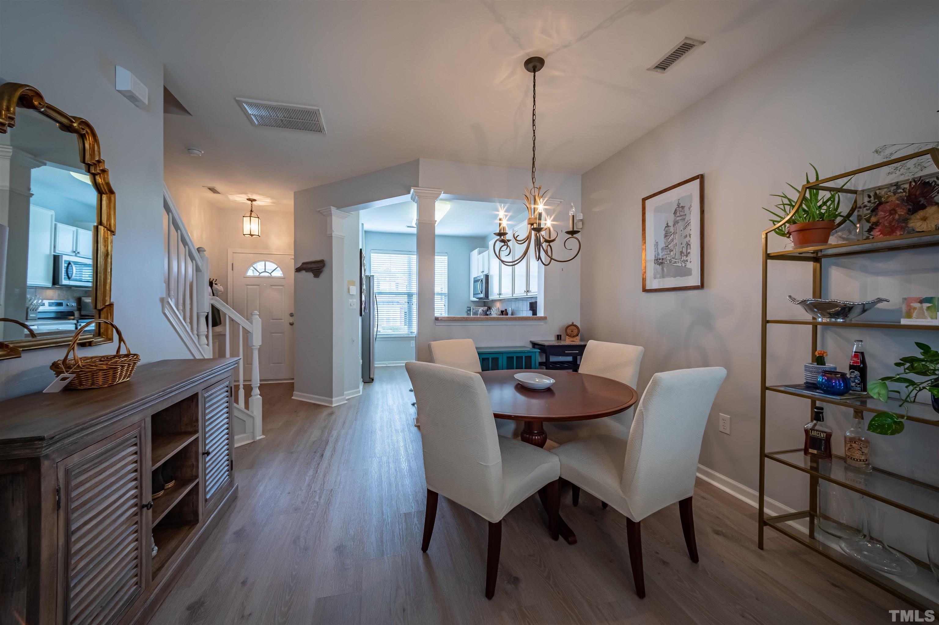 8447 Central Drive Raleigh, NC 27613 - Photo 3 of 19 a view of a dining room with furniture a chandelier and wooden floor