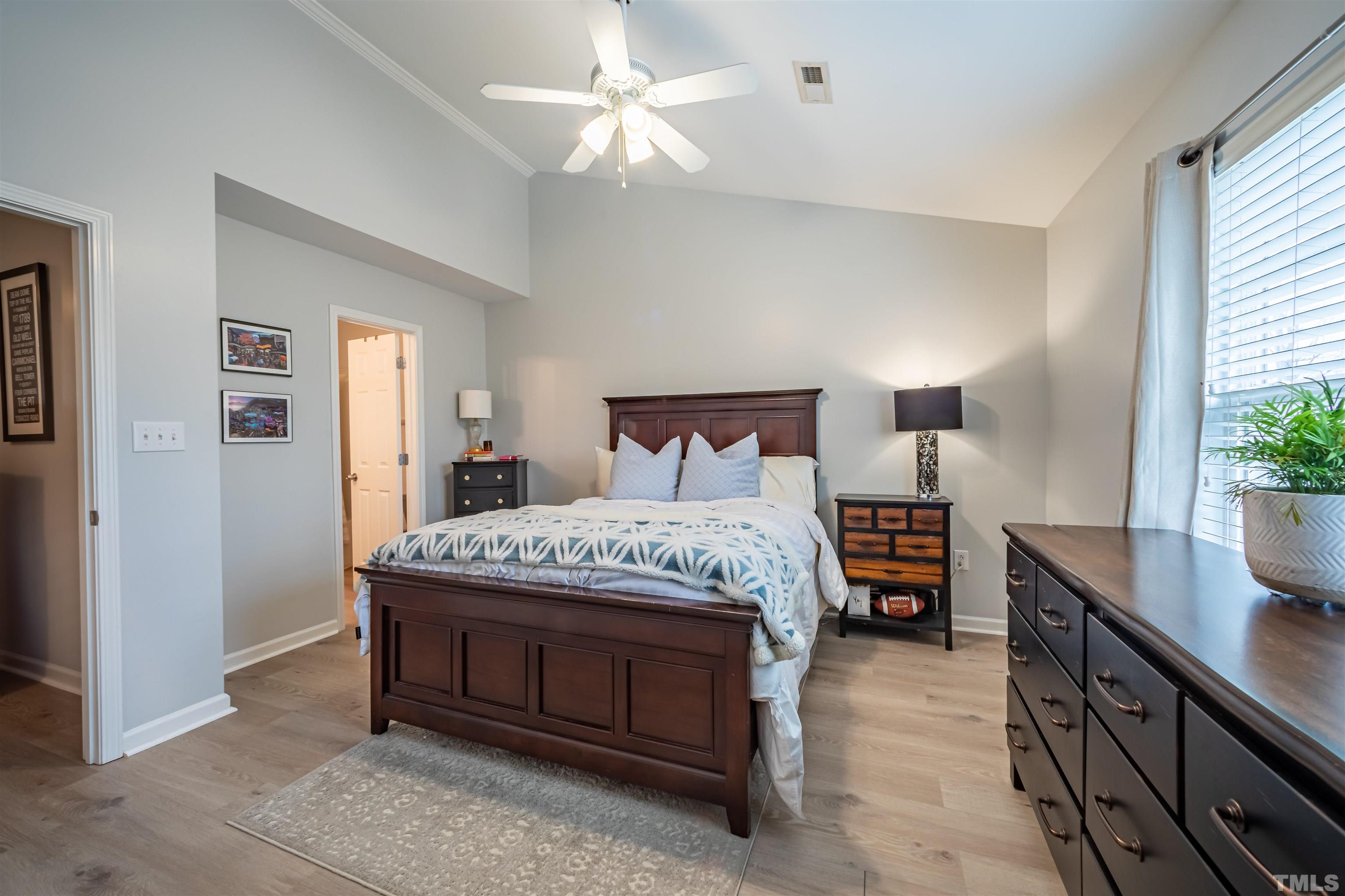 8447 Central Drive Raleigh, NC 27613 - Photo 10 of 19 a bedroom with a large bed and a chandelier