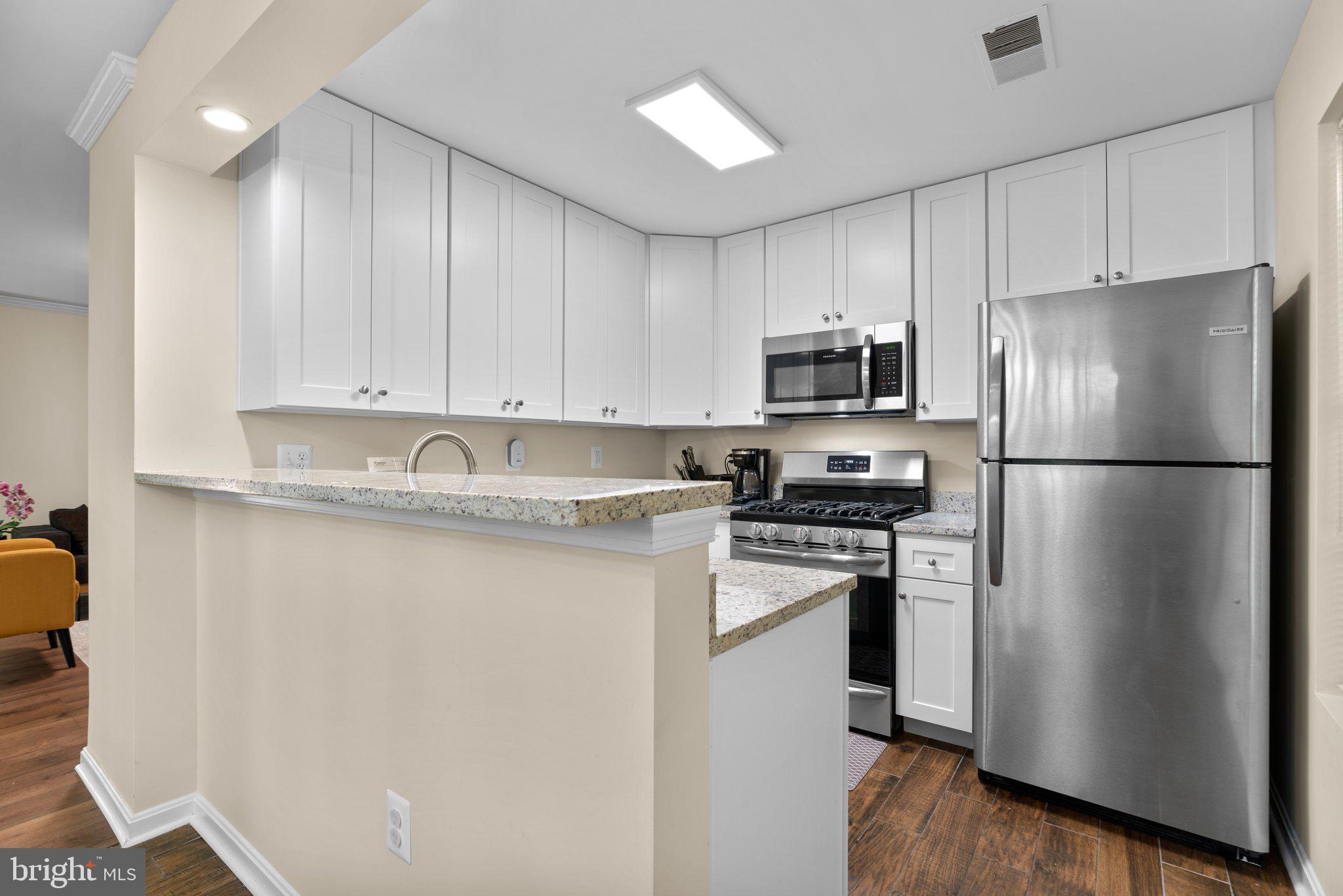 125 Timberbrook Lane, Unit T2 Gaithersburg, MD 20878 - Photo 12 of 30 a kitchen with stainless steel appliances granite countertop a refrigerator a stove a sink and a microwave