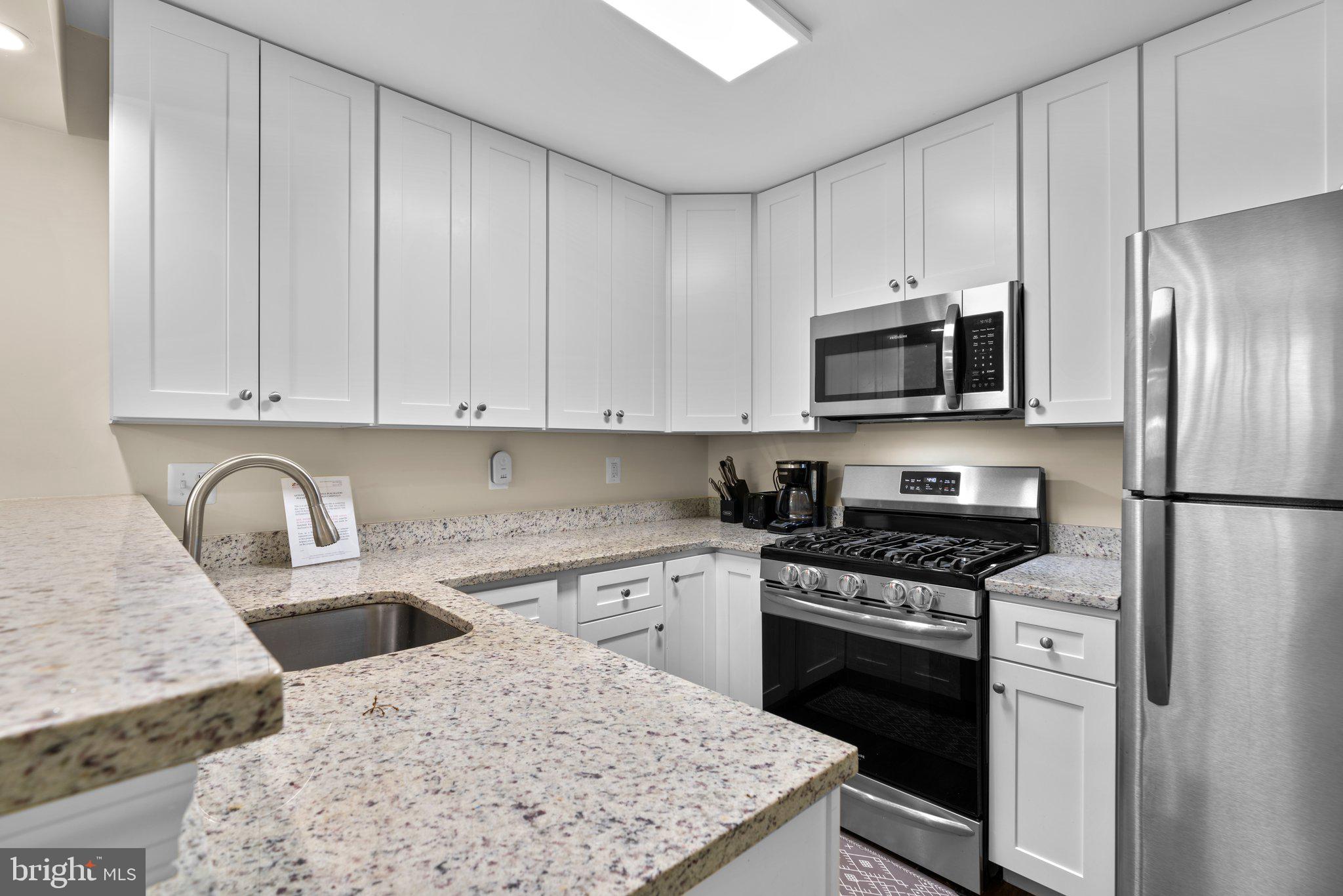 125 Timberbrook Lane, Unit T2 Gaithersburg, MD 20878 - Photo 13 of 30 a kitchen with stainless steel appliances granite countertop a stove refrigerator sink and microwave