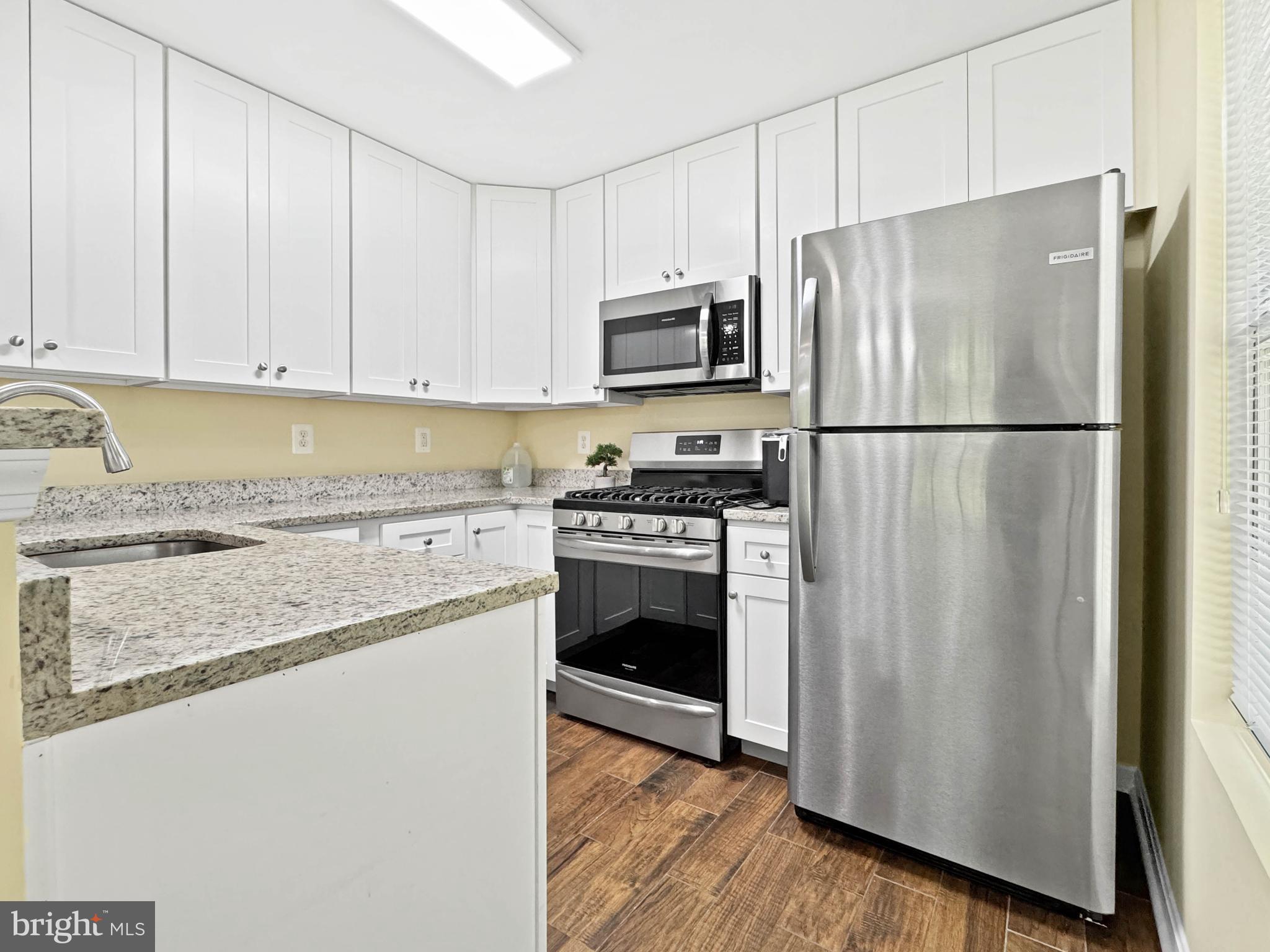125 Timberbrook Lane, Unit T2 Gaithersburg, MD 20878 - Photo 14 of 30 a kitchen with stainless steel appliances granite countertop a refrigerator stove and microwave