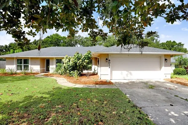 a front view of a house with a garden and yard