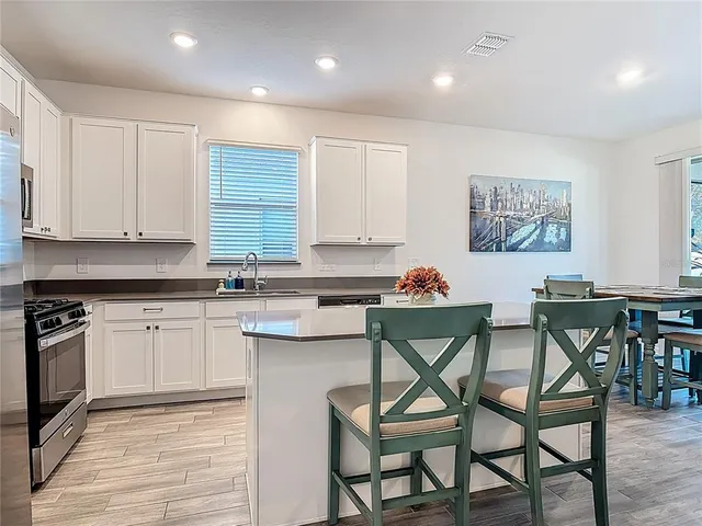 a kitchen with stainless steel appliances granite countertop a stove a sink and a refrigerator