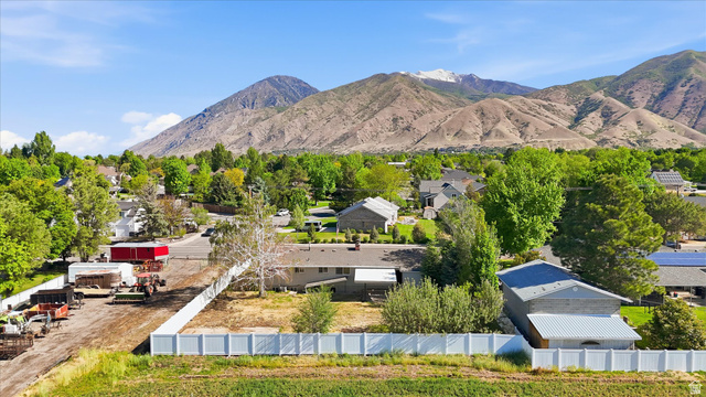 810 East Maple Street Mapleton, UT 84664 - Photo 48 of 49 Expansive property with a white perimeter fence, featuring partial mountain scenery, mature trees, and a clear sky