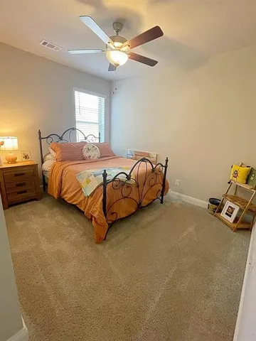 a spacious bedroom with a bed and a chandelier
