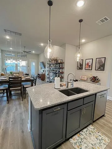 a kitchen with sink and view of wooden floor