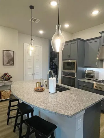 a kitchen with granite countertop a table chairs stove and refrigerator