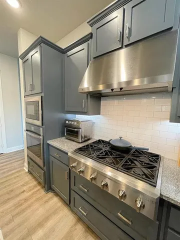 a stove top oven sitting inside of a kitchen