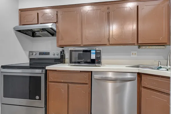 a kitchen with stainless steel appliances a microwave and a refrigerator