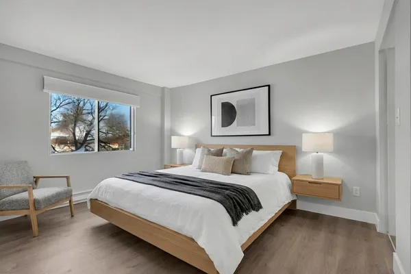 a bedroom with a bed lamp and a window