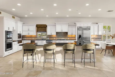 a kitchen with stainless steel appliances kitchen island granite countertop a table and chairs