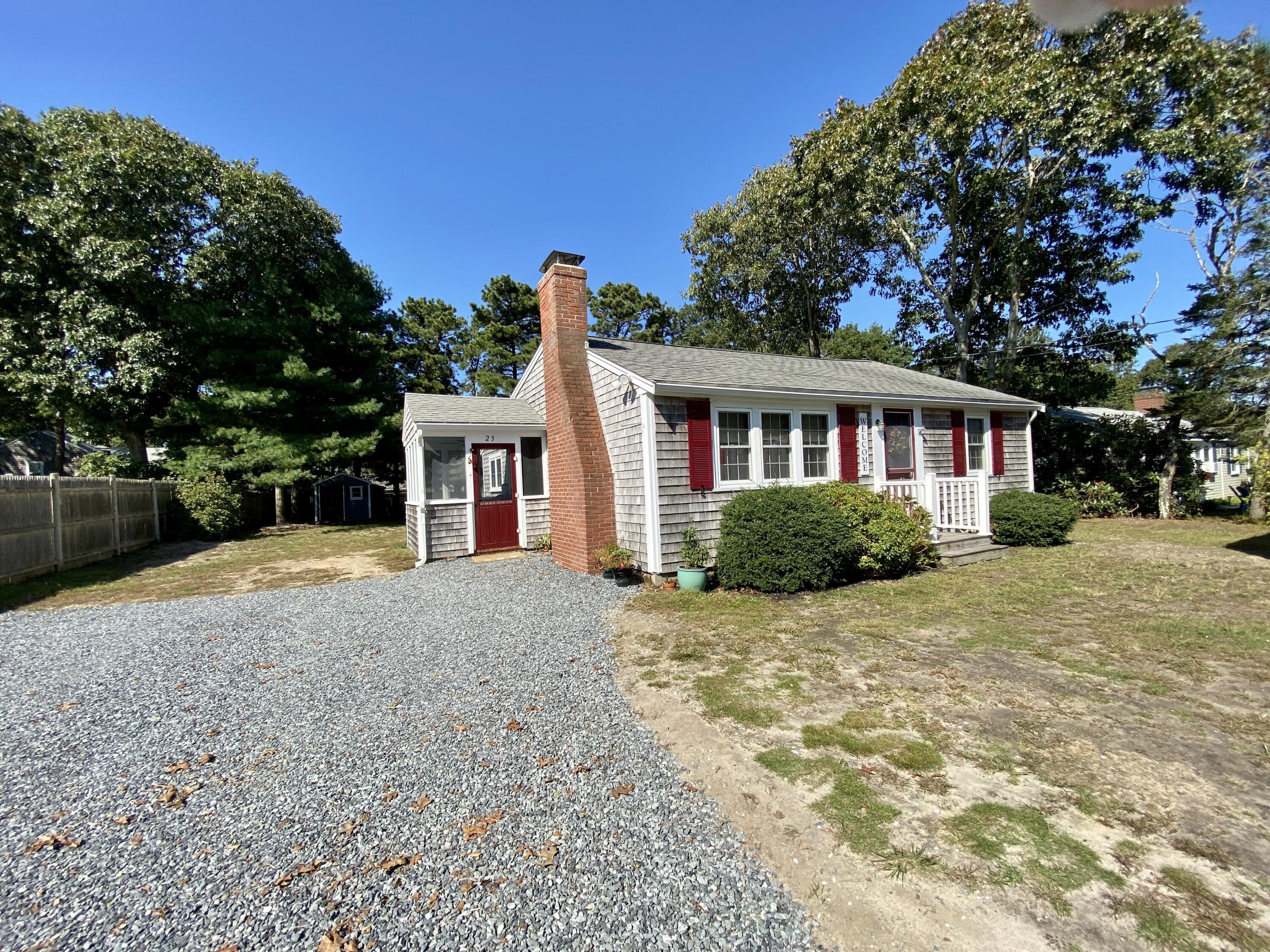 a view of a house with a yard and potted plants