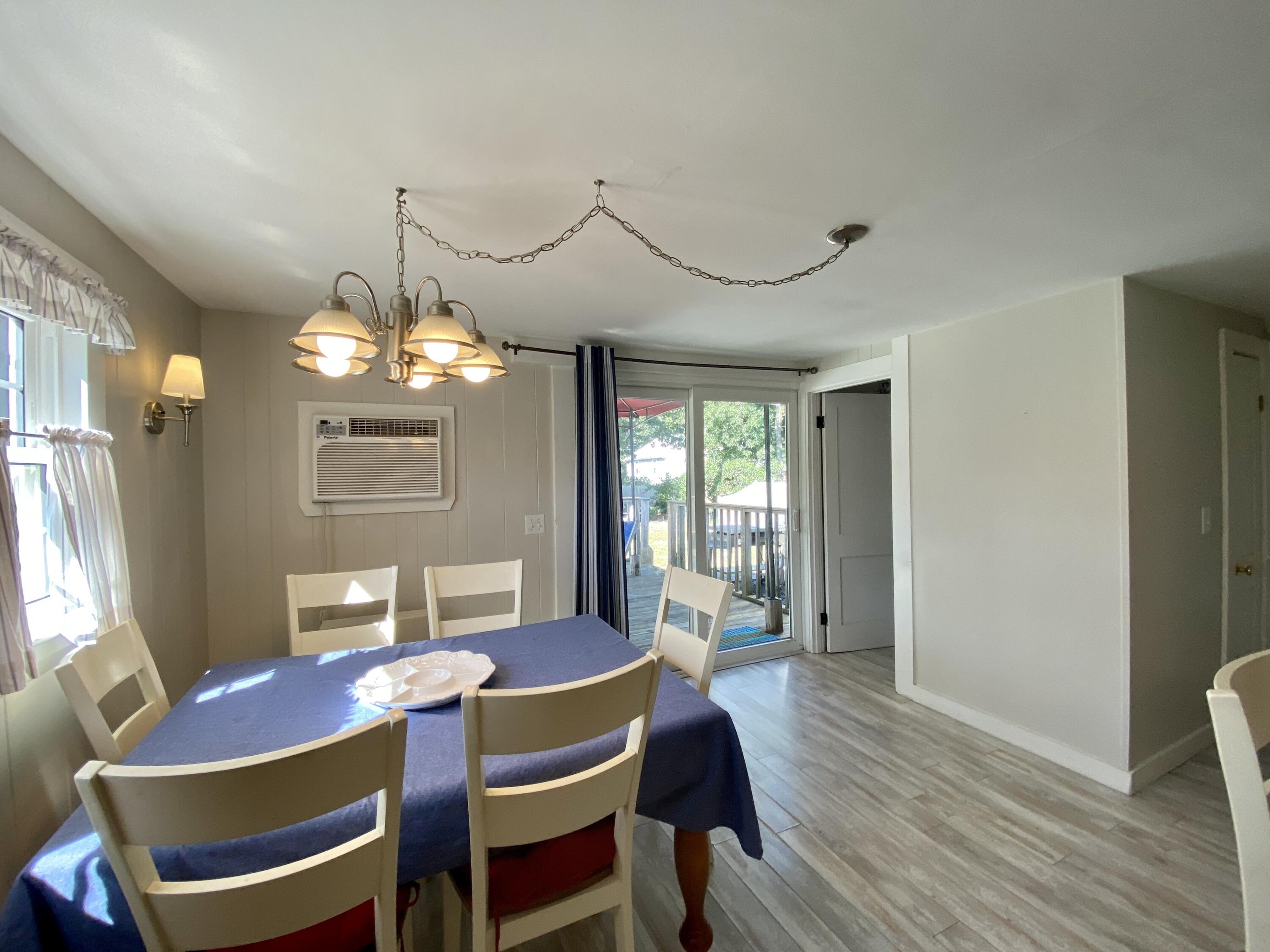 23 Naushon Road Dennis Port, MA 02639 - Photo 13 of 31 a view of a dining room with furniture a chandelier and wooden floor