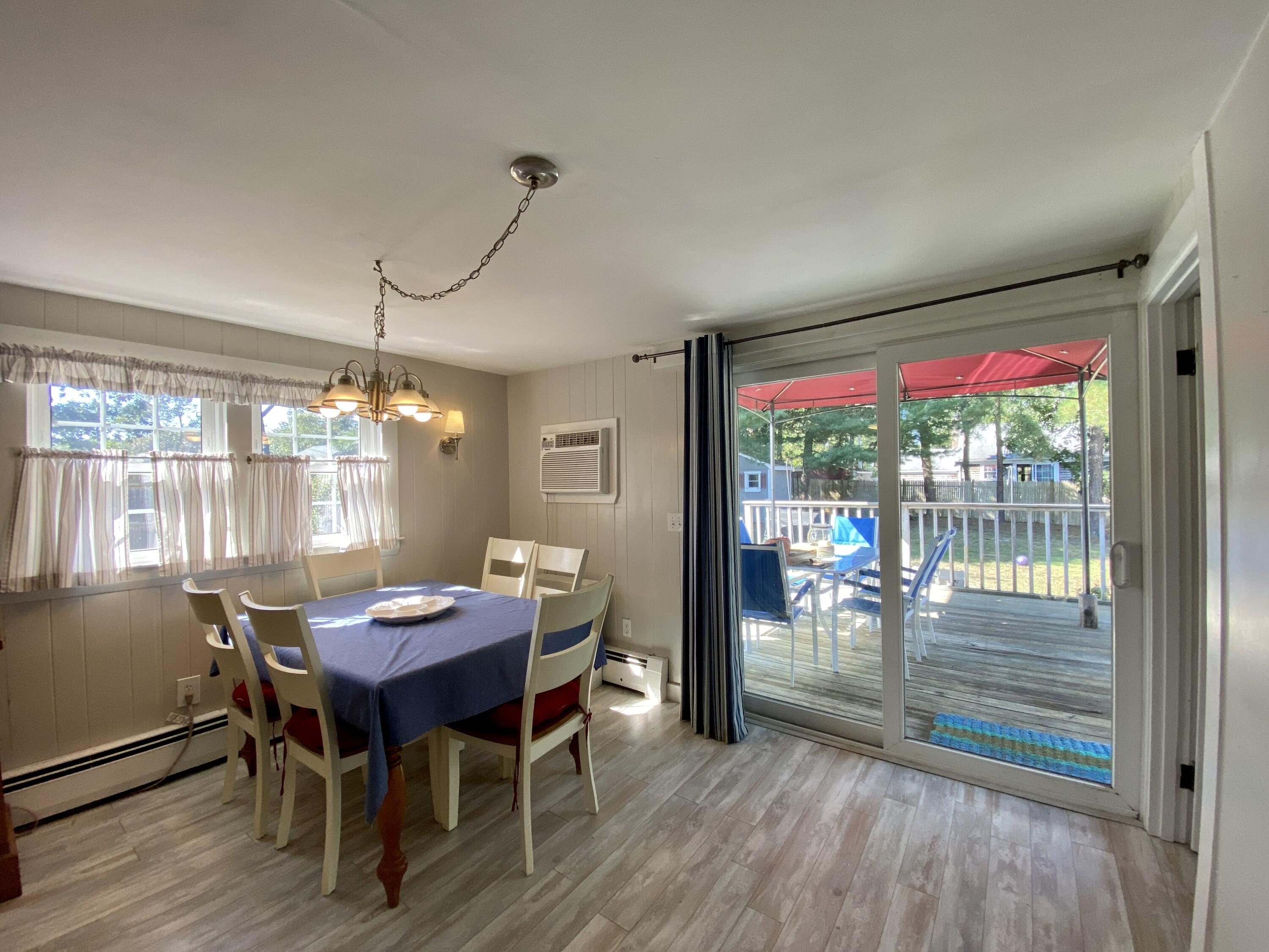 23 Naushon Road Dennis Port, MA 02639 - Photo 14 of 31 a view of a dining room with furniture wooden floor and chandelier