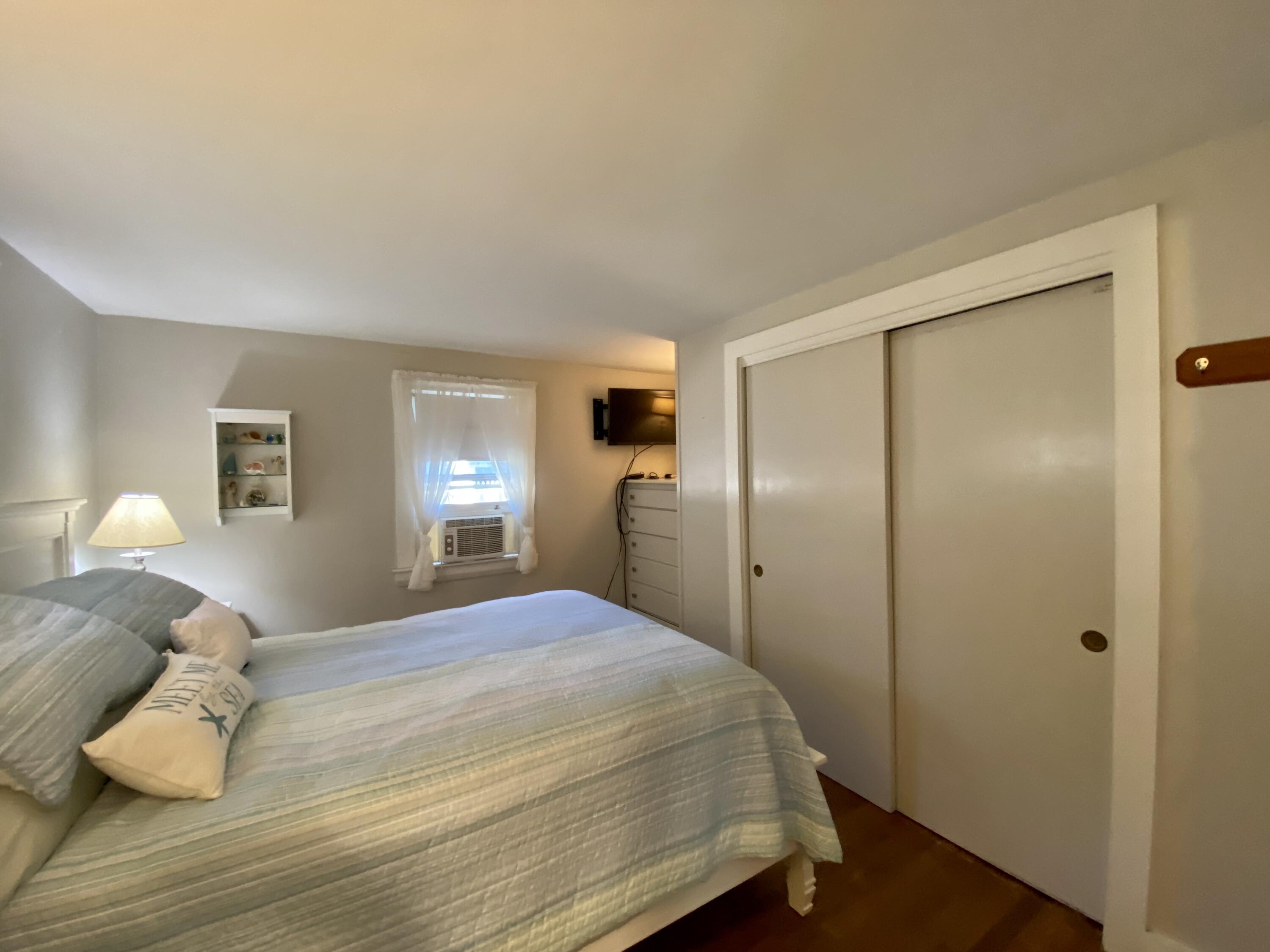 23 Naushon Road Dennis Port, MA 02639 - Photo 19 of 31 a bedroom with a bed and closet with wooden floor