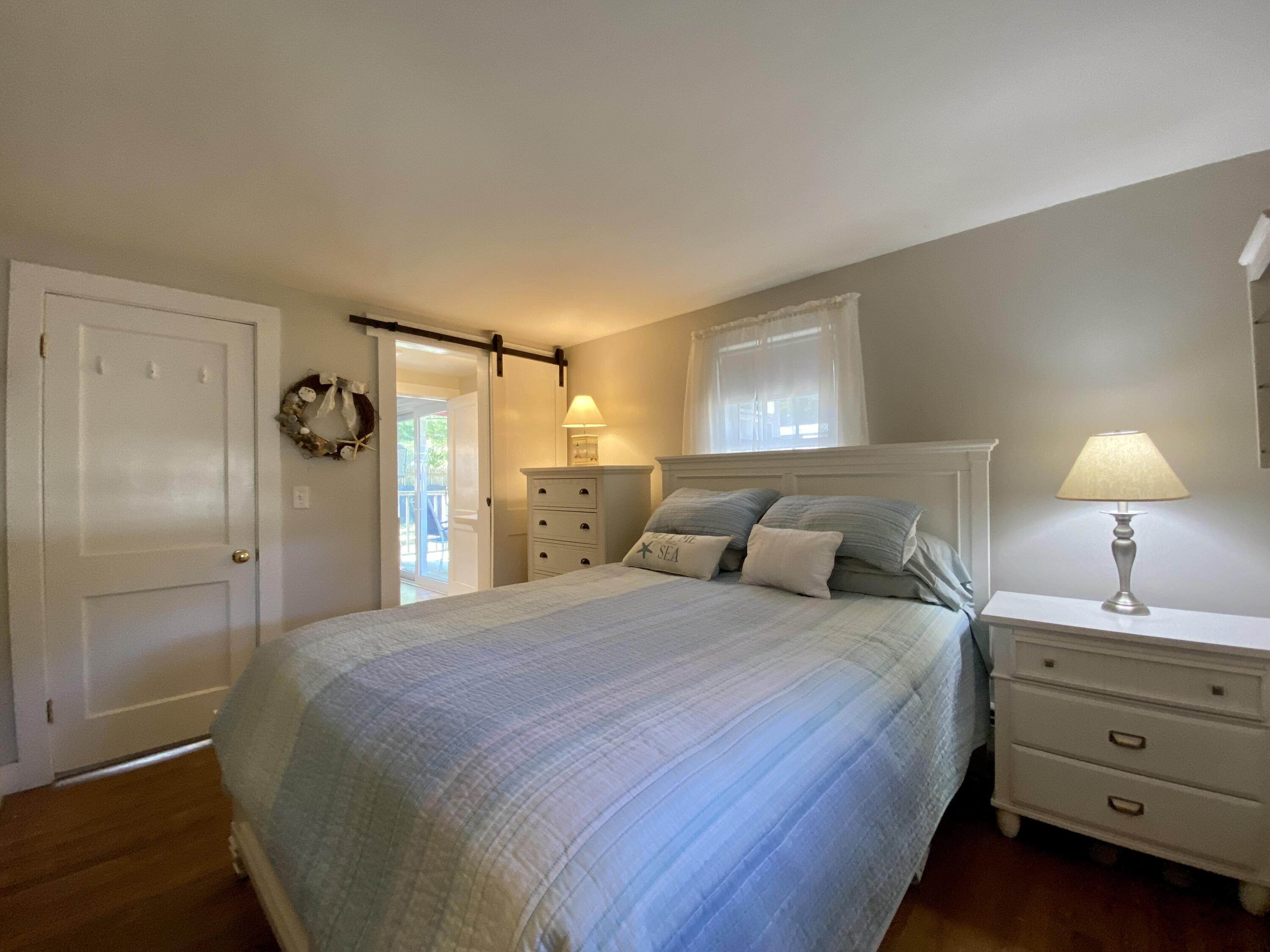 23 Naushon Road Dennis Port, MA 02639 - Photo 20 of 31 a bedroom with a bed and a lamp on dresser