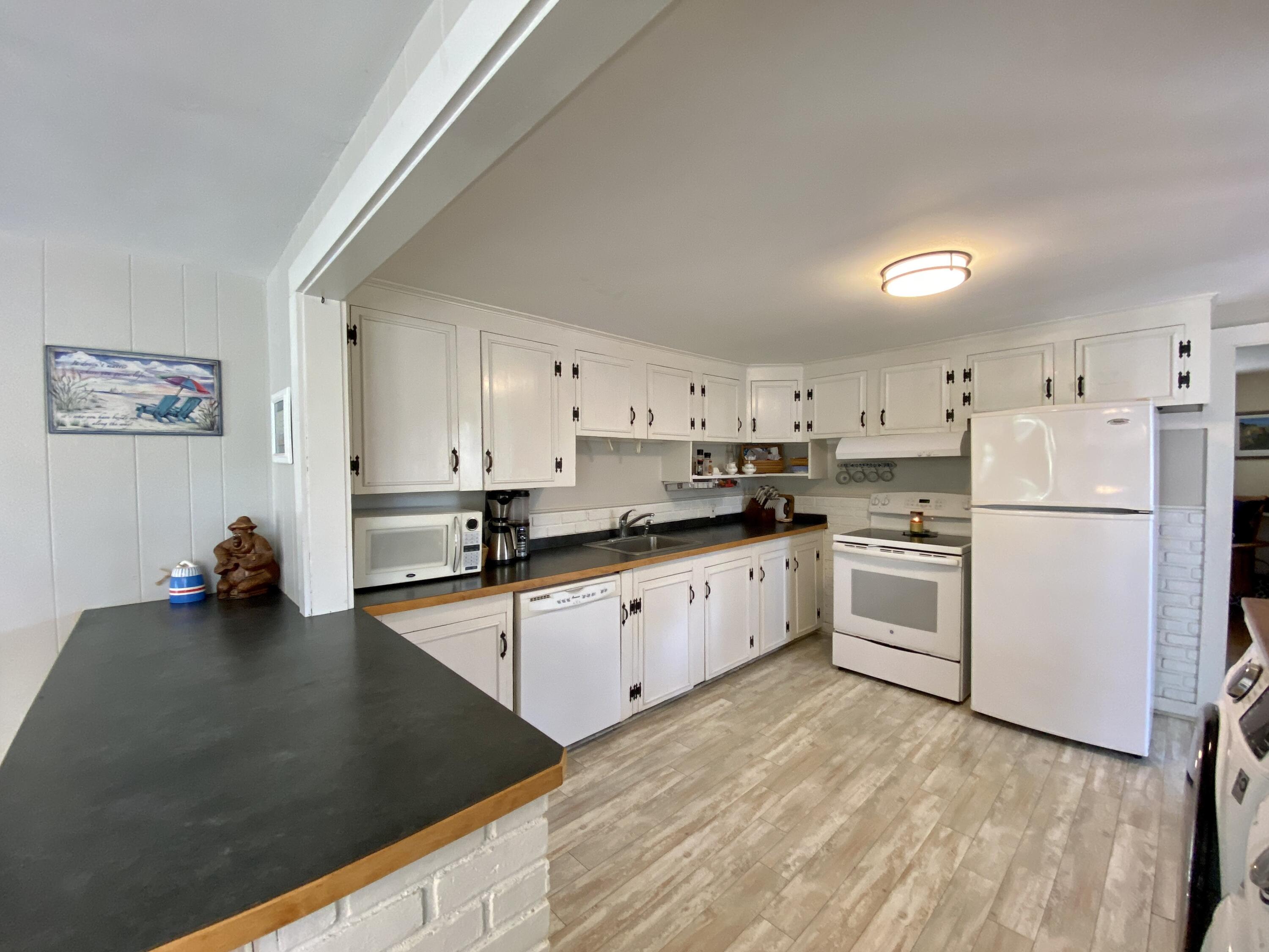 23 Naushon Road Dennis Port, MA 02639 - Photo 9 of 31 a kitchen that has a lot of cabinets a sink and appliances in it