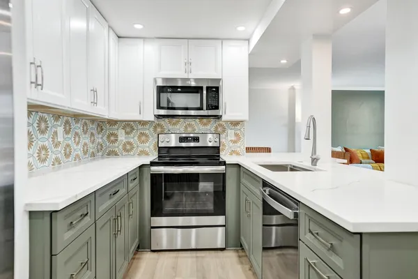 a kitchen with stainless steel appliances a stove microwave and sink