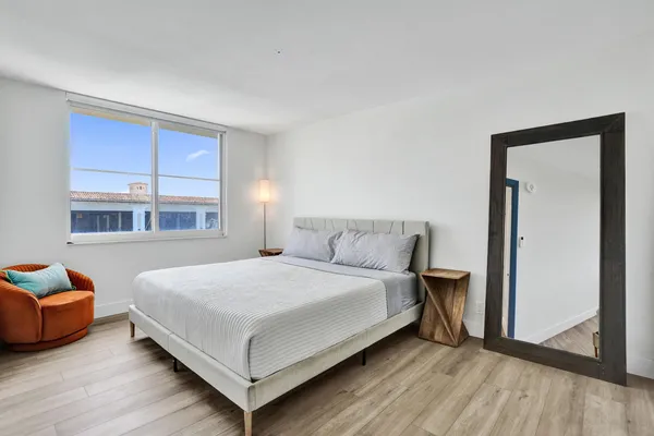 a bedroom with a bed and blue chair