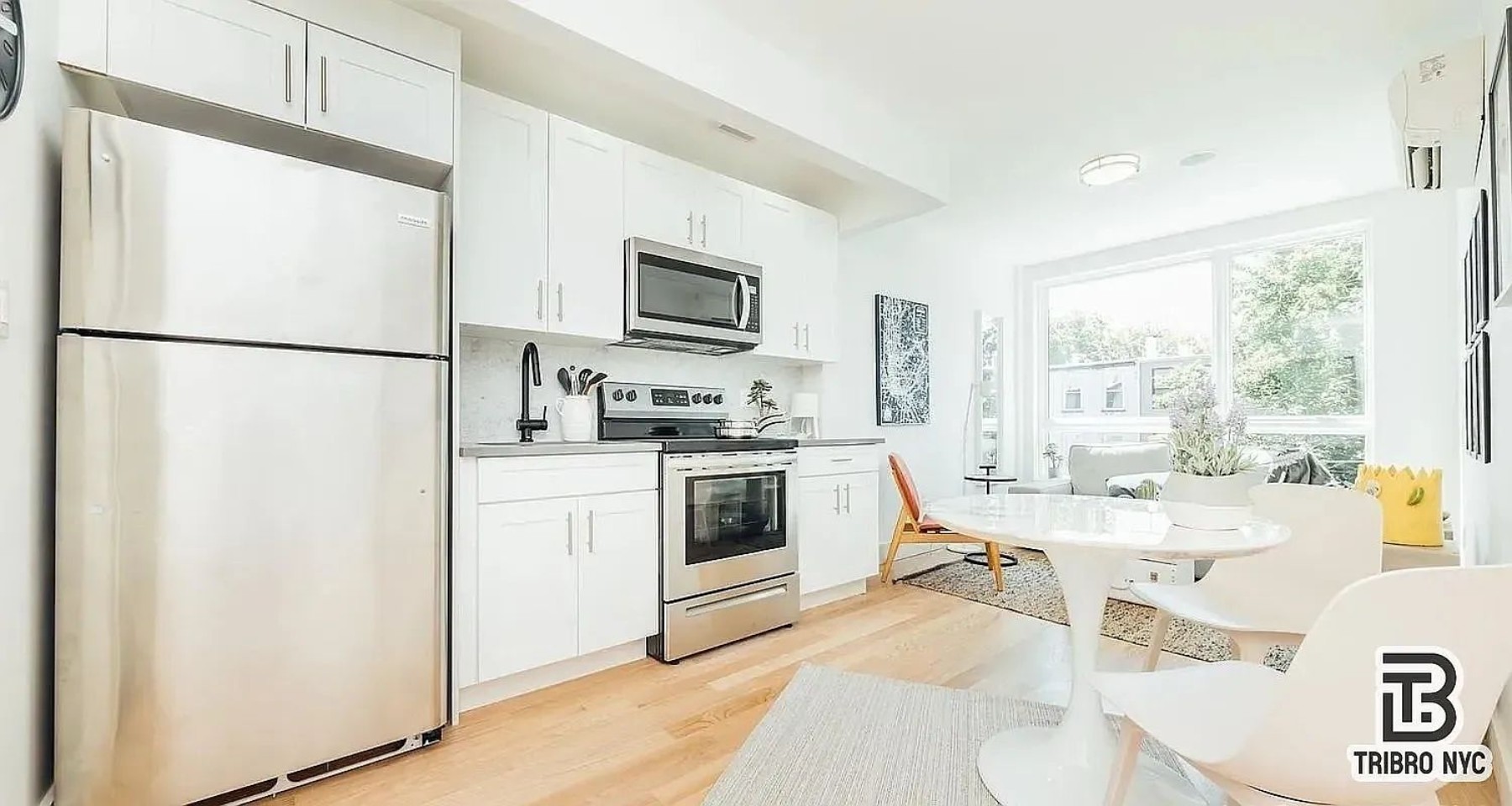 9 Cook Street, Unit 2F Brooklyn, NY 11206 - Photo 2 of 9 a kitchen with a refrigerator a stove a microwave a dining table and chairs
