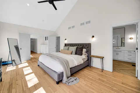 a spacious bedroom with a bed and wooden floor