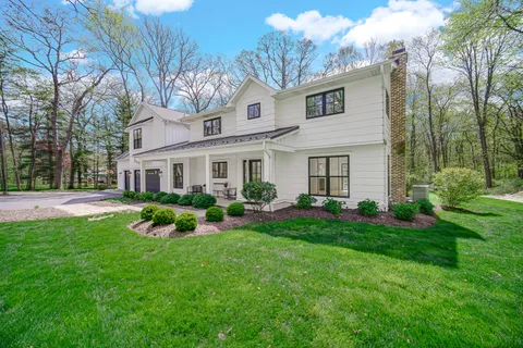 a front view of a house with yard and green space