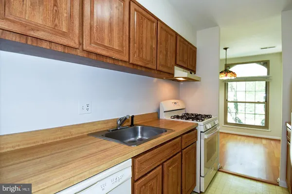 a kitchen with stainless steel appliances granite countertop a sink a stove and a wooden floors