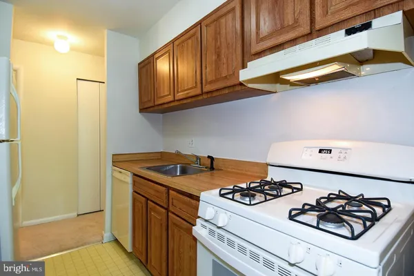 a kitchen with a stove and a white refrigerator