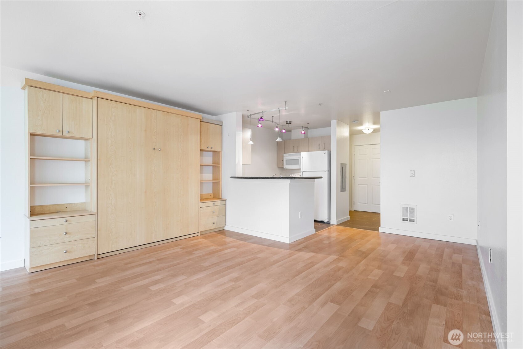 108 5th Avenue South, Unit 720 Seattle, WA 98104 - Photo 12 of 23 a view of a kitchen with wooden floor and a refrigerator