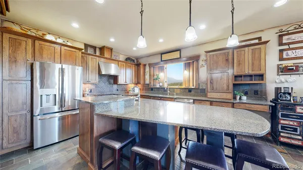 a large kitchen with a table chairs refrigerator and cabinets