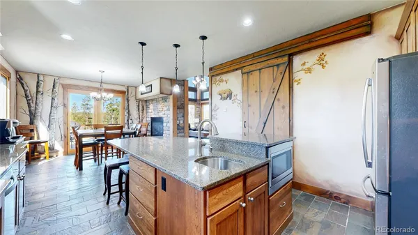 a kitchen with stainless steel appliances granite countertop a refrigerator a oven and a sink