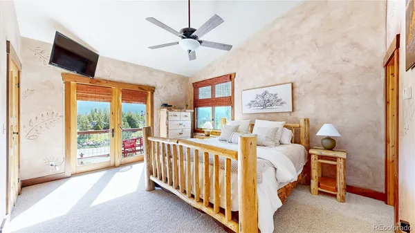a bedroom with a large bed and a chandelier
