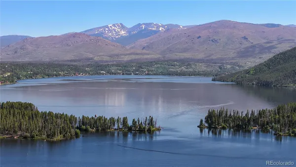 an aerial view of houses with a lake and mountain view
