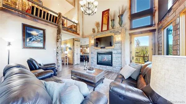 a living room with furniture a fireplace and a flat screen tv