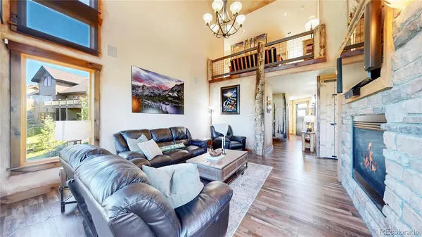 a living room with furniture a fireplace and wooden floor