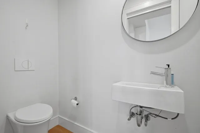 a bathroom with a toilet a sink and mirror