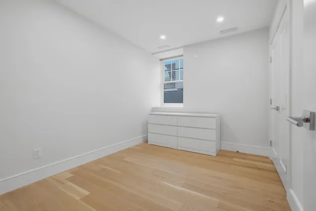 a room with a wooden floor and a window