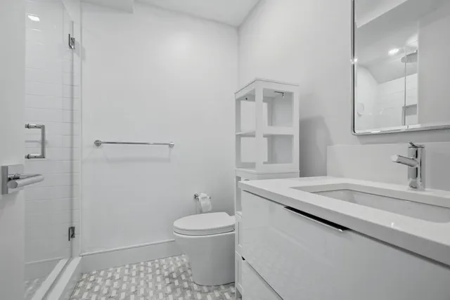 a bathroom with a sink a toilet and shower