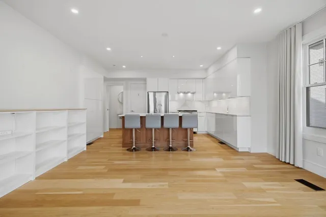 a view of kitchen with refrigerator cabinets and wooden floor