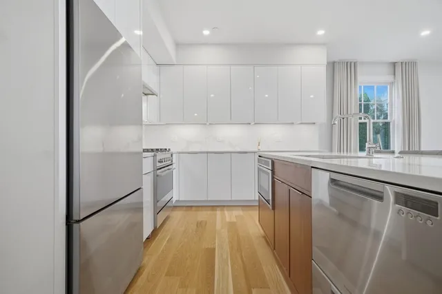 a kitchen with a sink a refrigerator and window