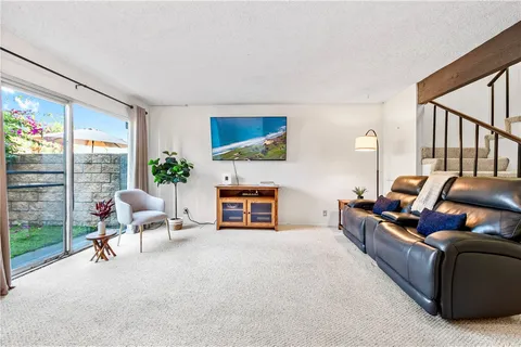 a living room with furniture a fireplace and a floor to ceiling window