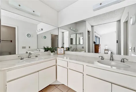 a bathroom with double sink and a mirror